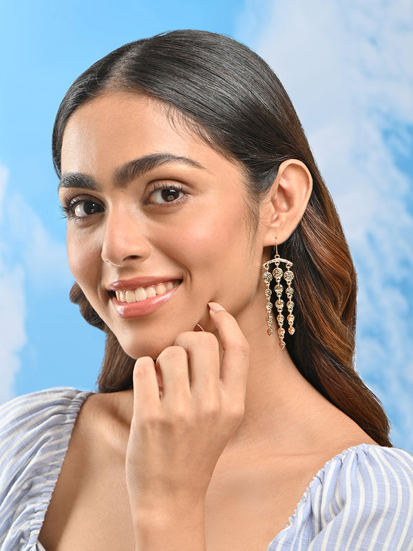 Woman wearing earrings with a blue background