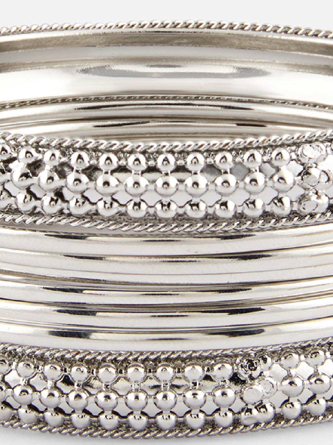 Close-up of silver bangles with textured design on a white background