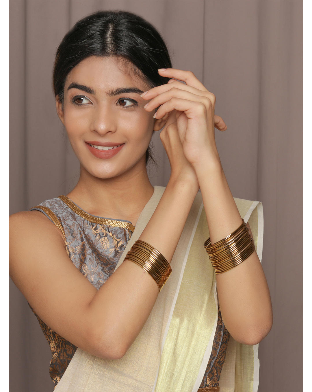 model wearing Fida set of 18 gold-plated metal bangles for women – sleek traditional Indian jewellery stack