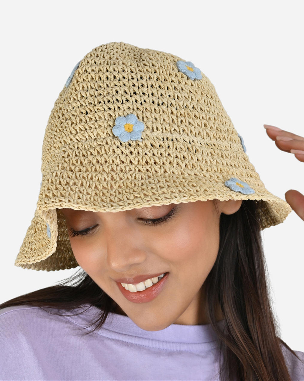 Woven straw hat with floral embellishments on a white background