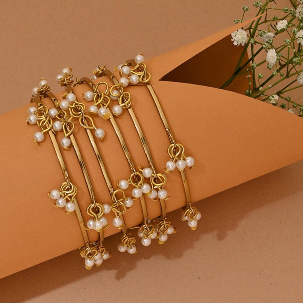 Gold hair sticks with pearls on a brown background