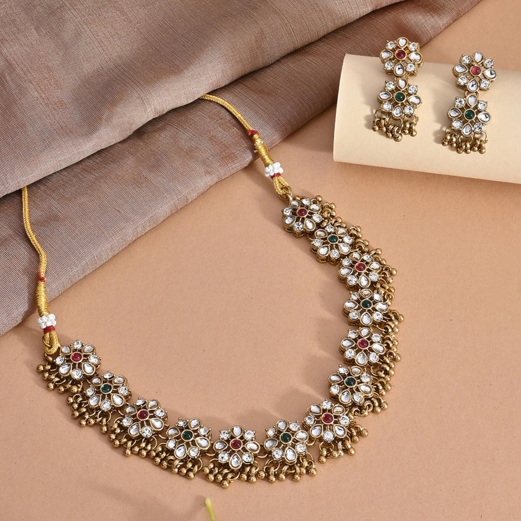 a gold floral temple meenakari choker necklace and matching earrings set