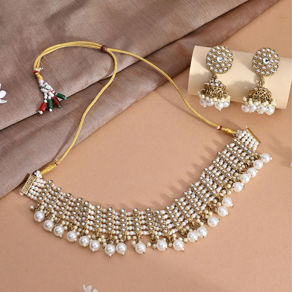 a white pearl and gold statement choker necklace and matching earrings set