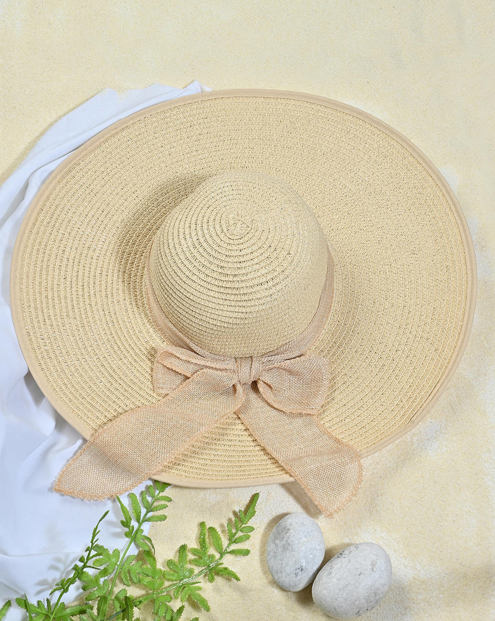a beige foldable sun hat with a bow on the brim