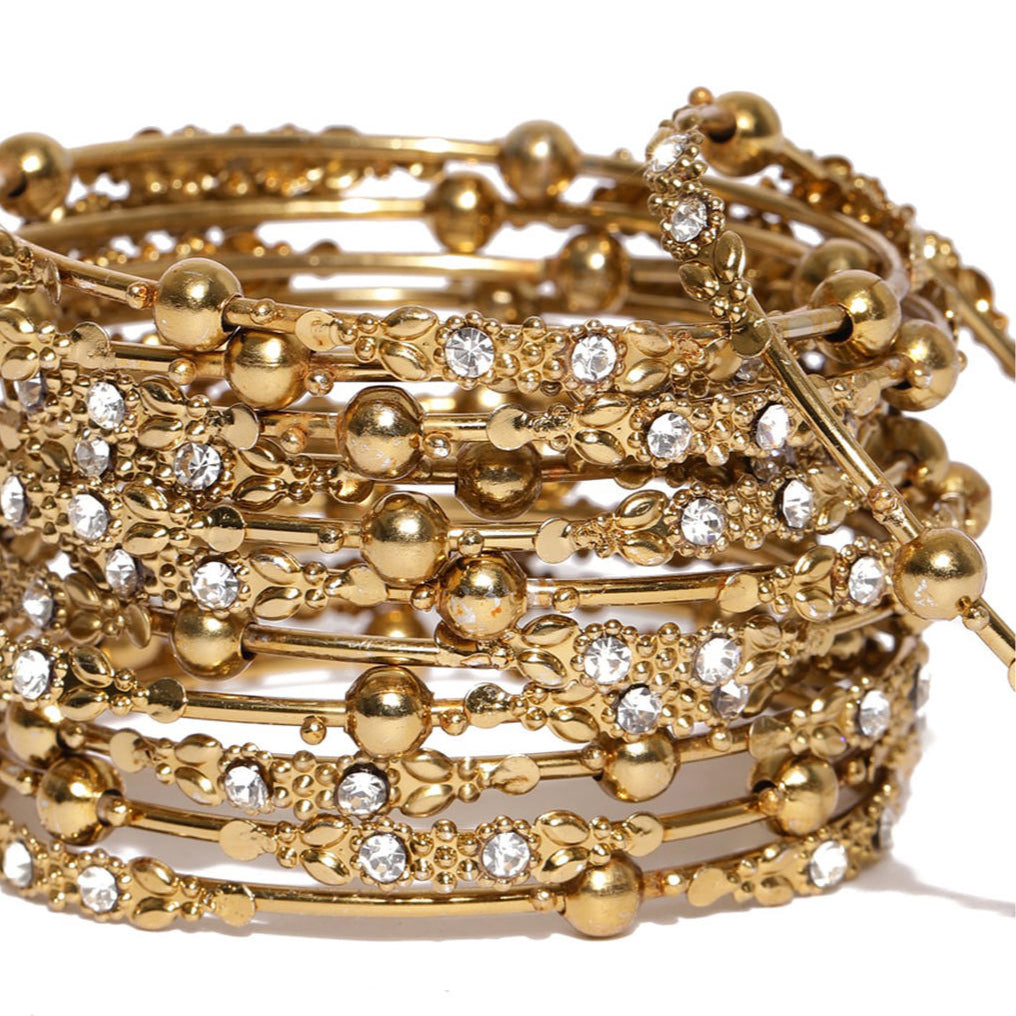 Set of 12 gold-plated metal bangles with sparkling stones and beads. Perfect ethnic jewellery for weddings, parties & traditional celebrations closeup.