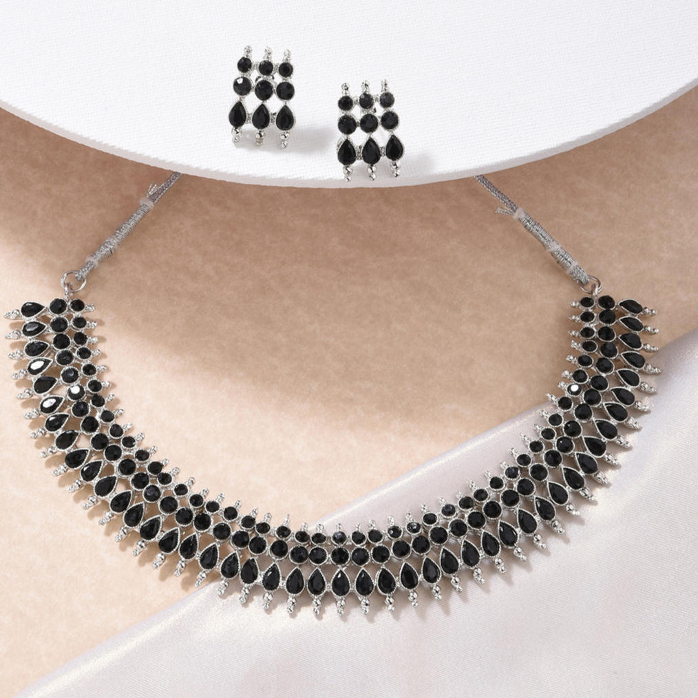 a traditional silver choker necklace with black beads and matching earrings.