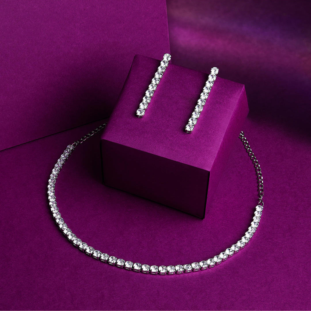 a silver plated necklace and earrings jewellery set with intricate motifs and American Diamond stones.
