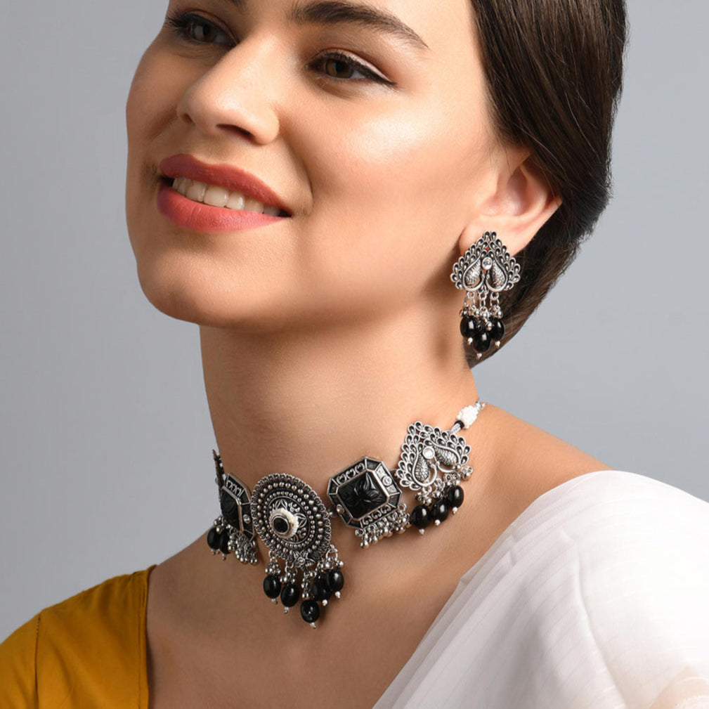a silver-plated oxidised black beaded peacock jewelry set which includes a necklace and a pair of earrings.