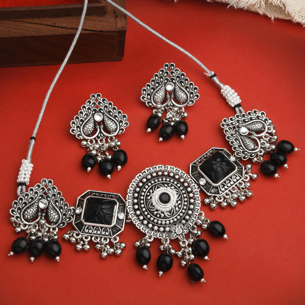 a silver-plated oxidised black beaded peacock jewelry set which includes a necklace and a pair of earrings.