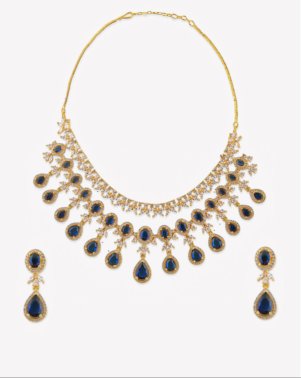 a luxurious bridal jewellery set which includes a necklace, earrings, and maang tikka, featuring blue sapphire stones and gold-tone metal.