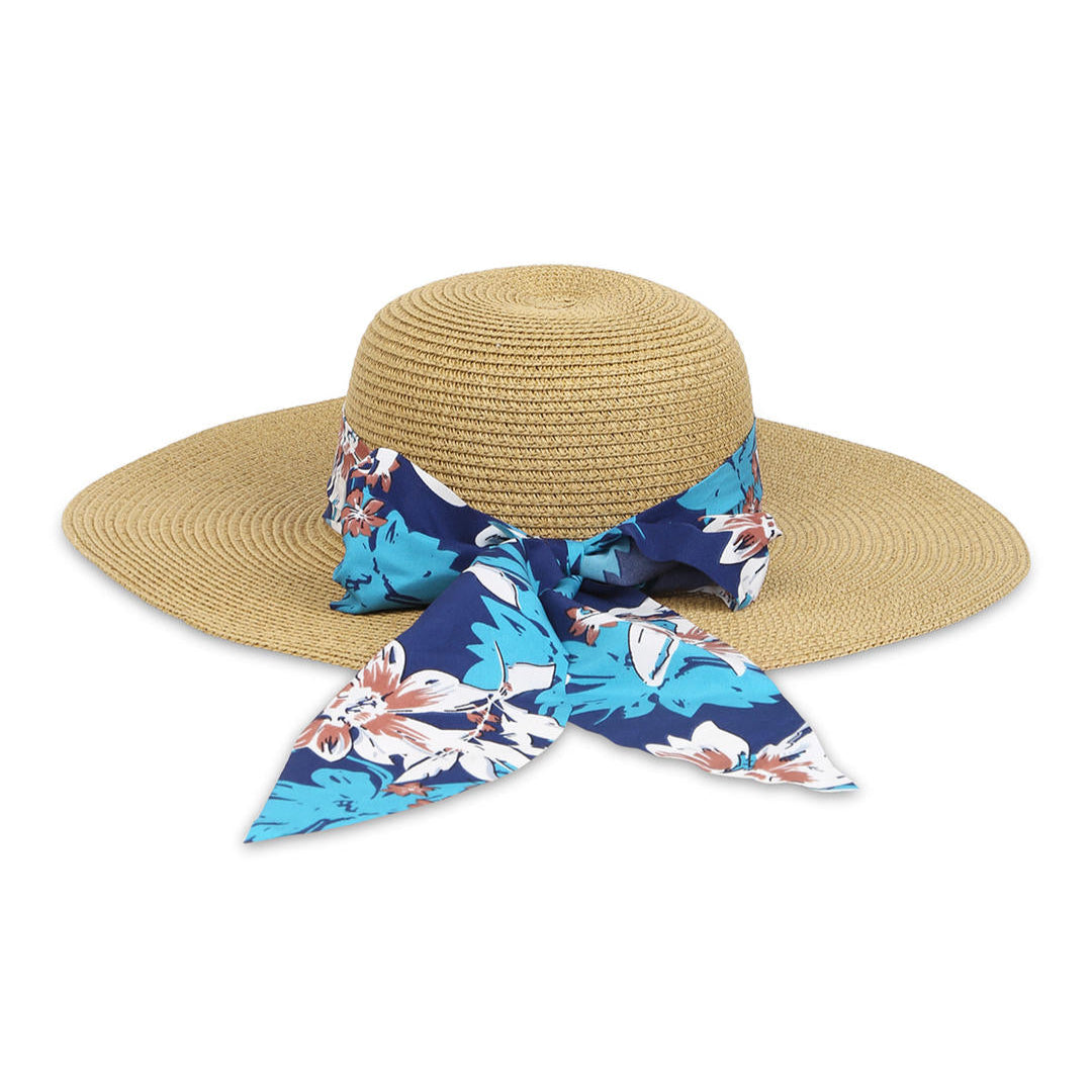 A beige beach hat with a blue floral scarf tied around the base.