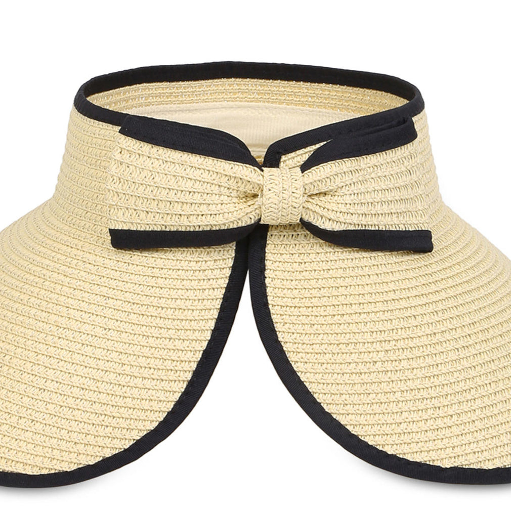 A beige sun visor with black edging and a bow at the back.