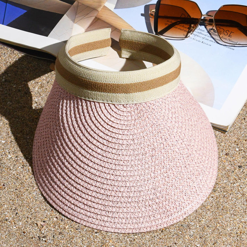A pink sun visor hat with a woven texture and a beige band.