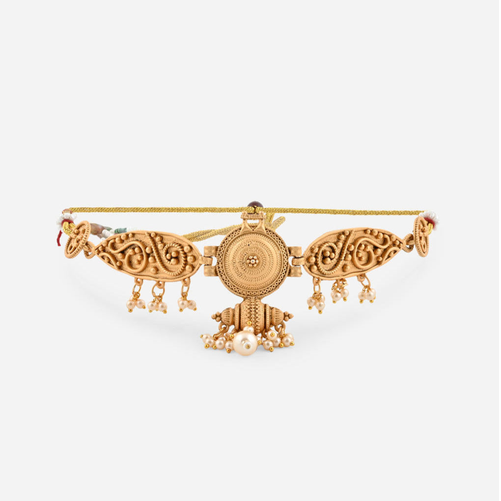 a gold-plated choker necklace with intricate designs and pearl accents, paired with matching earrings.