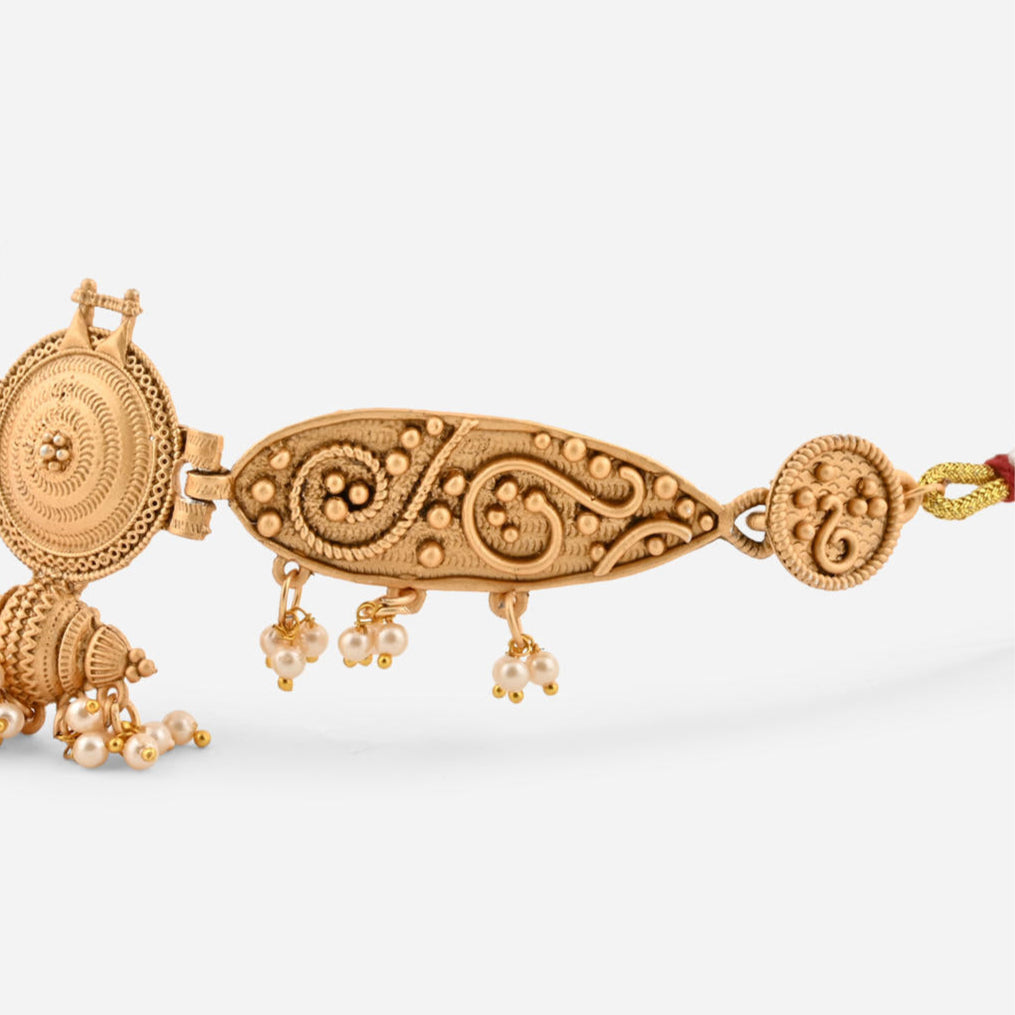 a gold-plated choker necklace with intricate designs and pearl accents, paired with matching earrings closeup