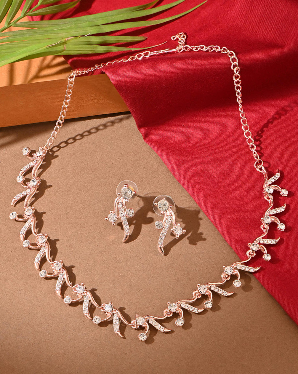 a rose gold floral party necklace and earrings set with sparkling stones.