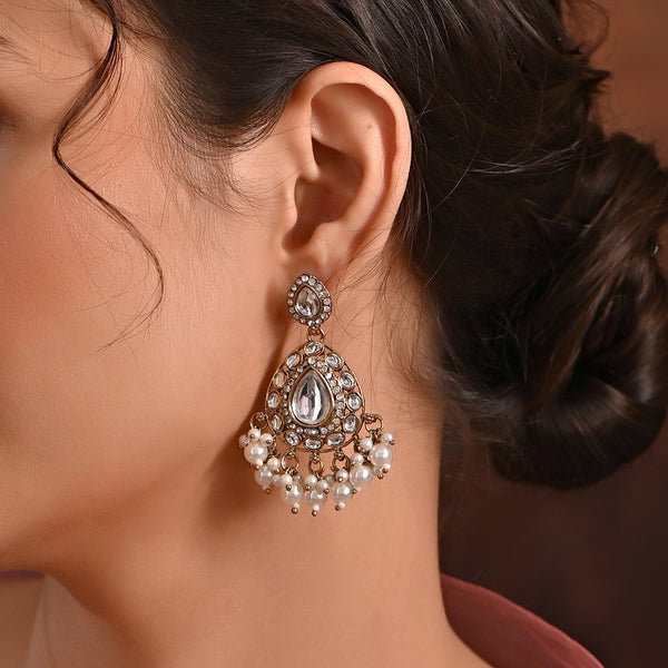 A pair of gold-plated ivory kundan stone drop earrings with ivory pearls.