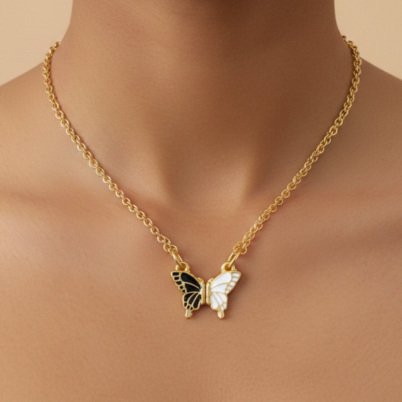 Gold necklace with a butterfly pendant on a beige background
