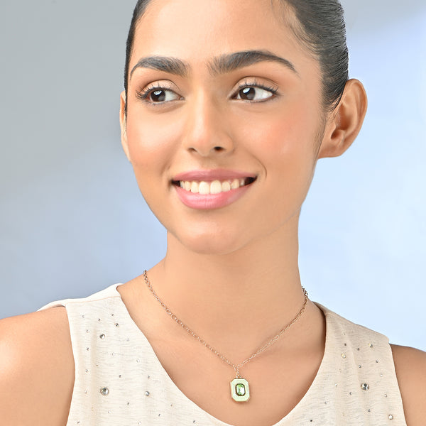 Woman wearing a necklace with a green pendant against a light blue background. ToniQ jewellery is skin safe, nickel free, cadmium free, hypoallergenic, and lab tested for your comfort and trust.