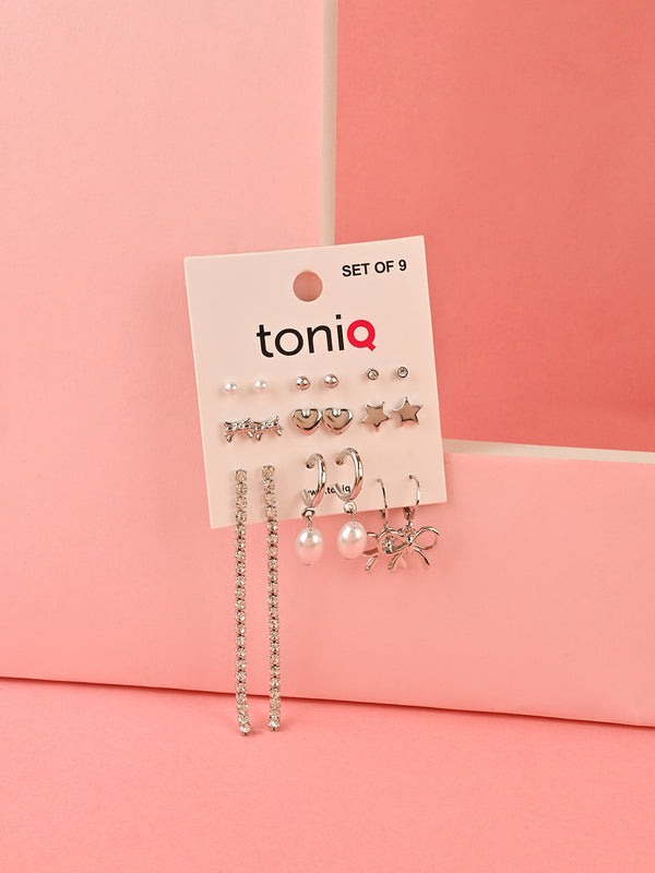 A collection of nine silver-colored stud and hoop earrings for women
