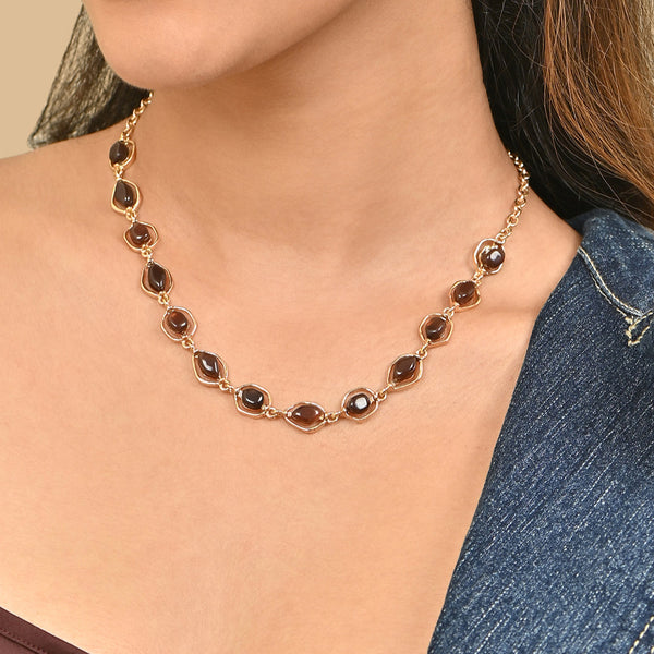 Necklace with brown gemstones worn by a person against a neutral background