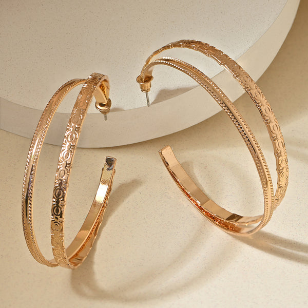 Gold hoop earrings with intricate designs on a beige background. ToniQ jewellery is skin safe, nickel free, cadmium free, hypoallergenic, and lab tested for your comfort and trust.