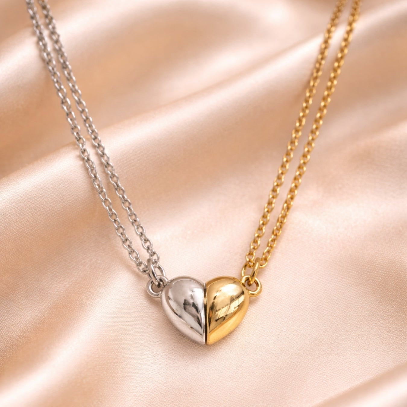 Two-tone heart-shaped pendant necklace on a soft pink background