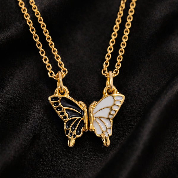 Butterfly-shaped pendant on a gold chain against a black background