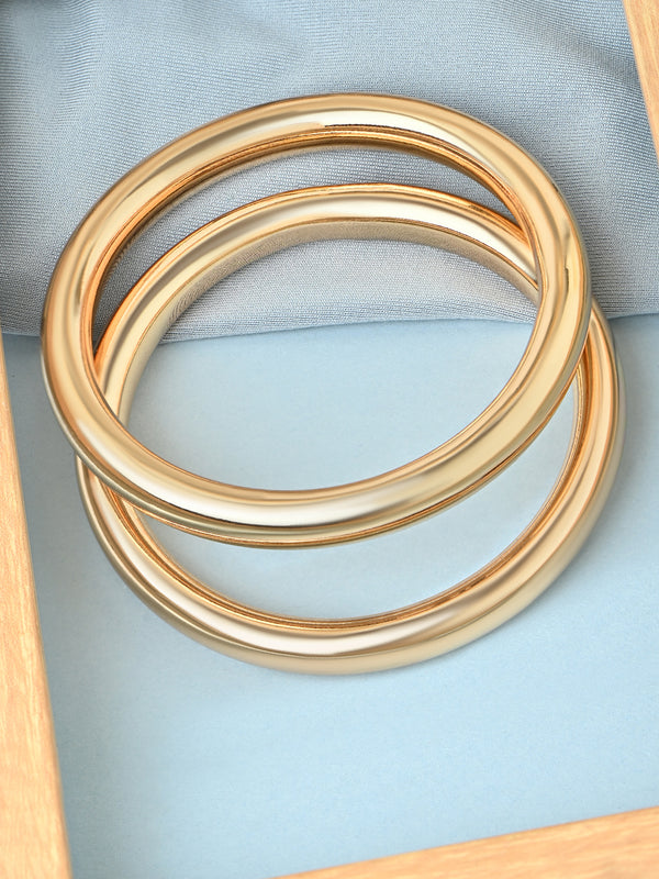 Three gold Bangle bracelet stacked on a light blue fabric background. ToniQ jewellery is skin safe, nickel free, cadmium free, hypoallergenic, and lab tested for your comfort and trust.
