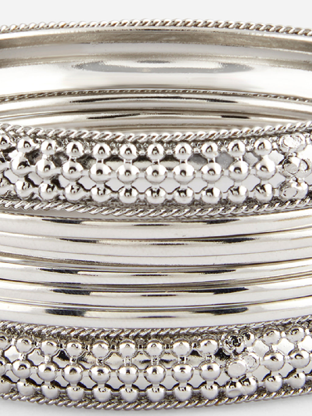 Close-up of silver bangles with textured design on a white background