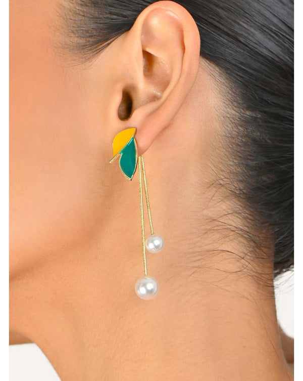 A woman wearing green and yellow floral pearl drop earrings.