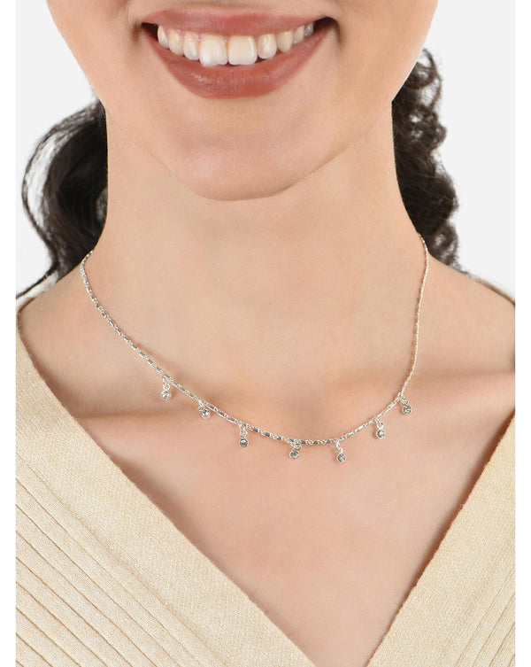 A woman wearing a silver plated multi charm choker necklace with CZ stone studs.