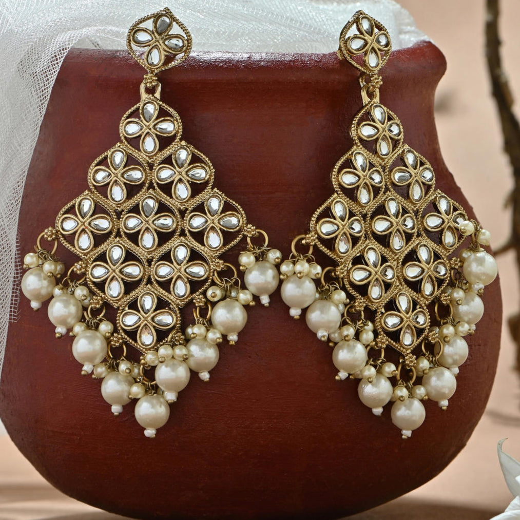 A white kundan stone drop earrings with a traditional design.