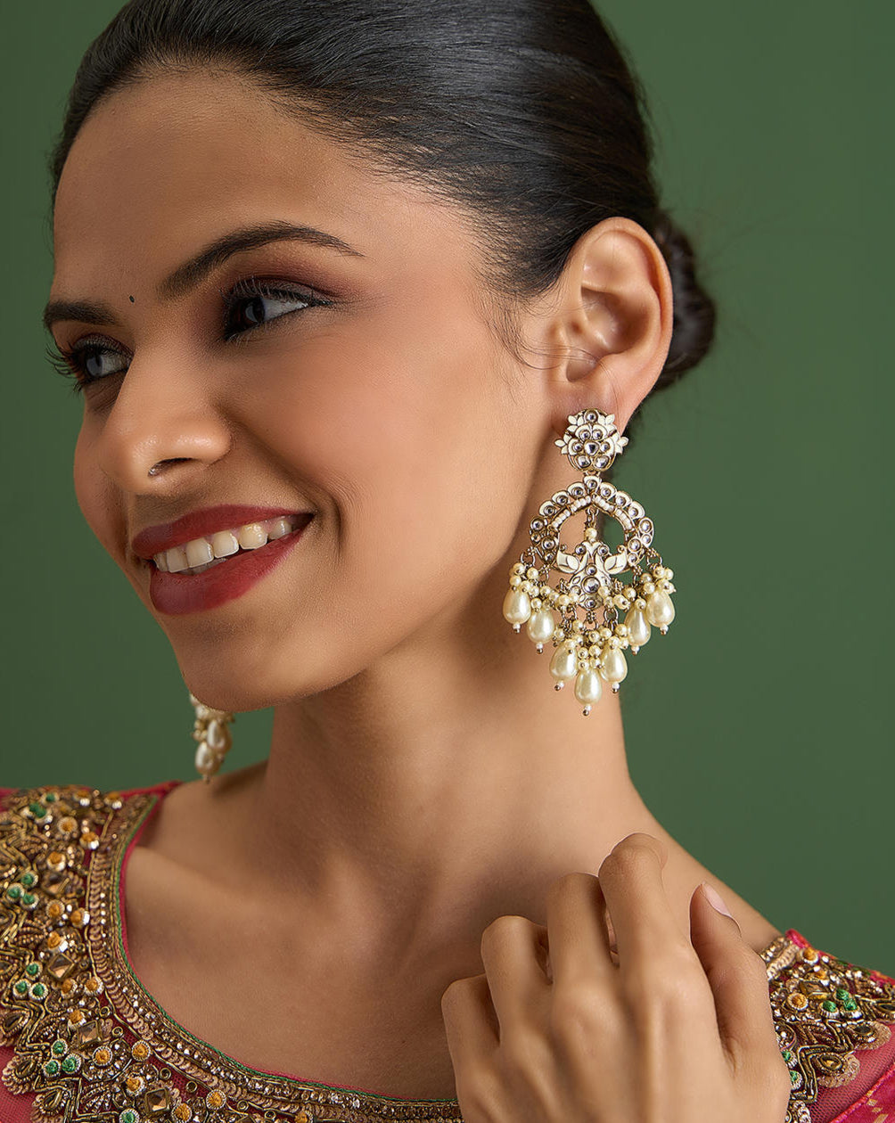 A pair of gold-toned Chandbali earrings with white Meenakari detailing and pearl drops