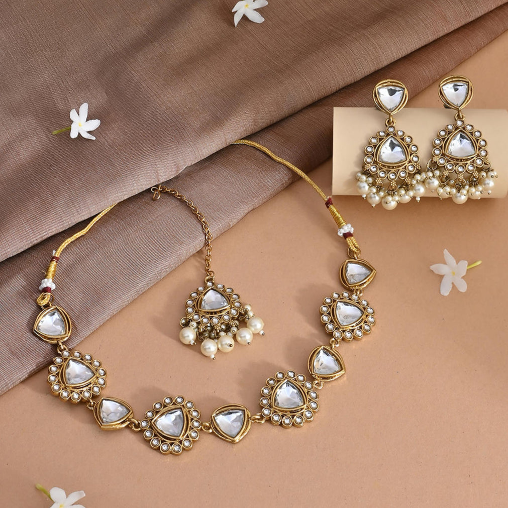 white pearl and kundan-studded bridal necklace, earrings, and a maang tikka set with white pearl and kundan-studded gold-plated designs.