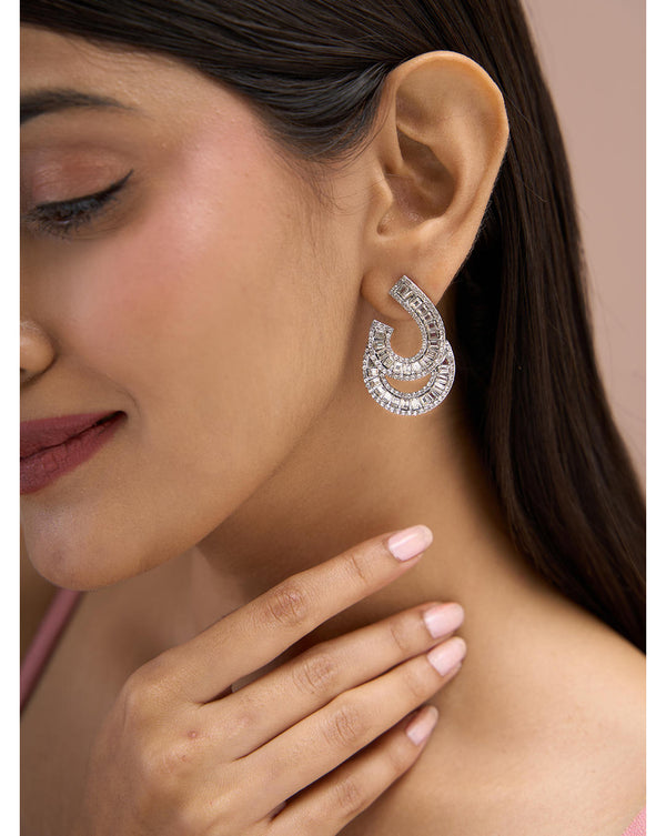A woman wearing silver cocktail wear stud earrings with cubic zirconia stones.