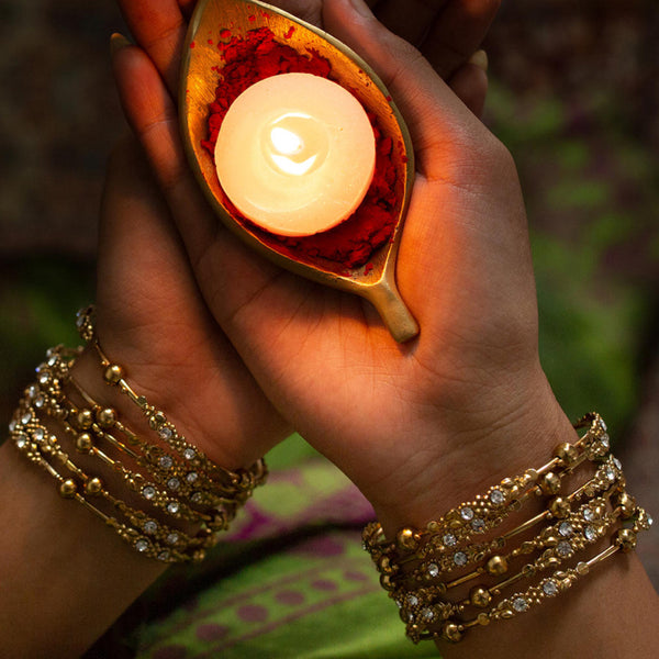Set of 12 gold-plated metal bangles with sparkling stones and beads. Perfect ethnic jewellery for weddings, parties & traditional celebrations.