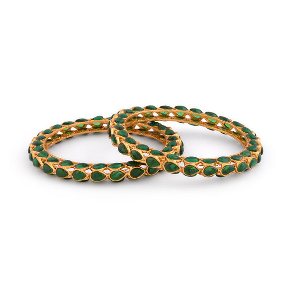 A set of two gold-plated bangles adorned with emerald stones and kundan work, displayed against a white background.