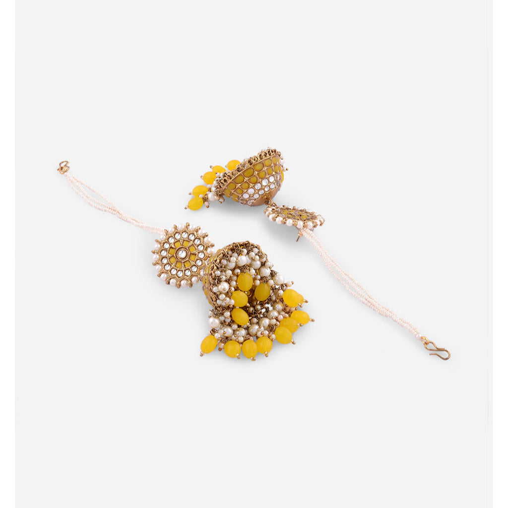 A pair of yellow drop earrings with gold plating and embellishments, featuring artificial beads and stone decorations.