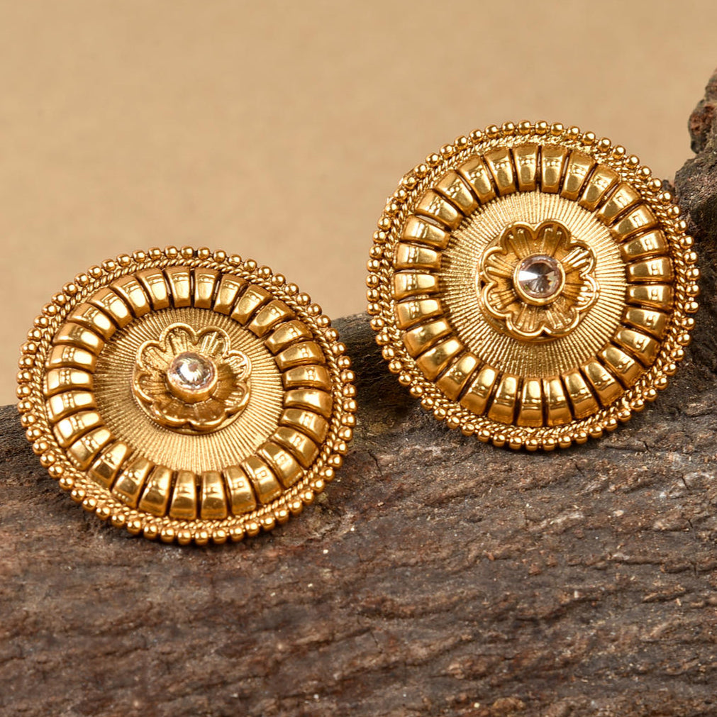 A pair of gold-plated antique floral stud earrings with intricate floral patterns and a central decorative motif, displayed against a neutral background.
