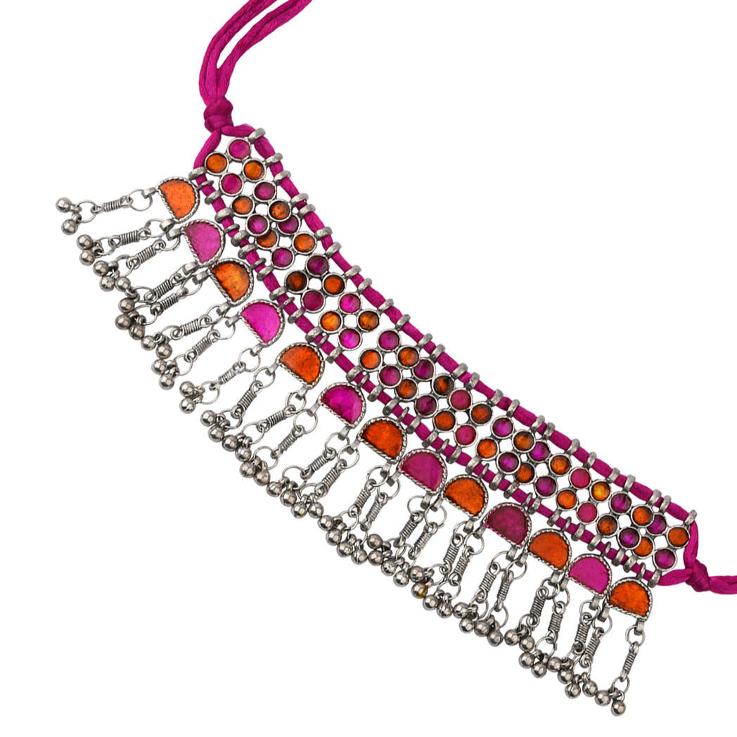 A pink and silver choker necklace with oxidised silver work and vibrant stone inlay close-up on white background