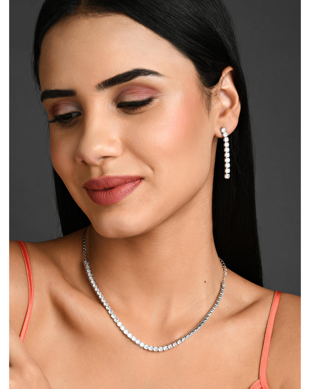 a silver-plated necklace and earrings jewellery set with intricate motifs and American Diamond stones.