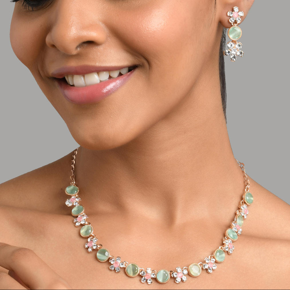 gold plated floral jewellery set with pink and green stones, with matching earrings.