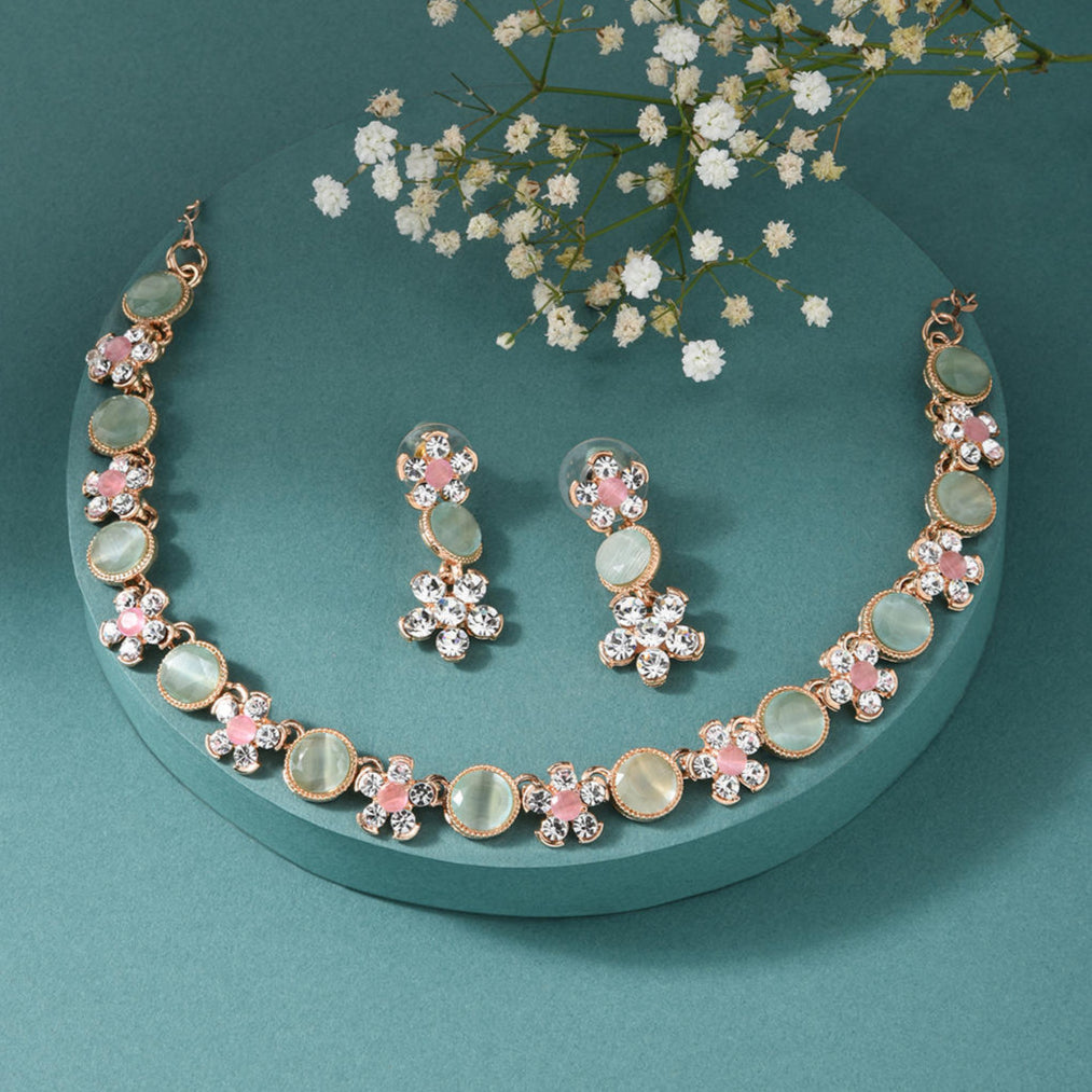 gold plated floral jewellery set with pink and green stones, with matching earrings.
