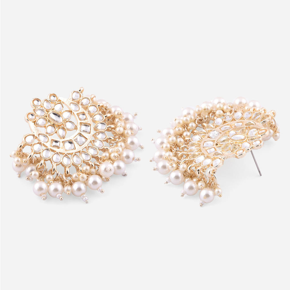 a traditional Indian ethnic gold and white pearl kundan choker necklace, earrings, and maang tikka set.