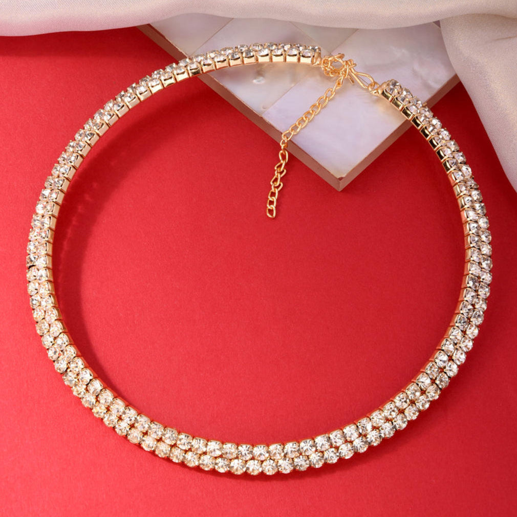 a gold-toned choker necklace adorned with cubic zirconia stones product closeup in a red background