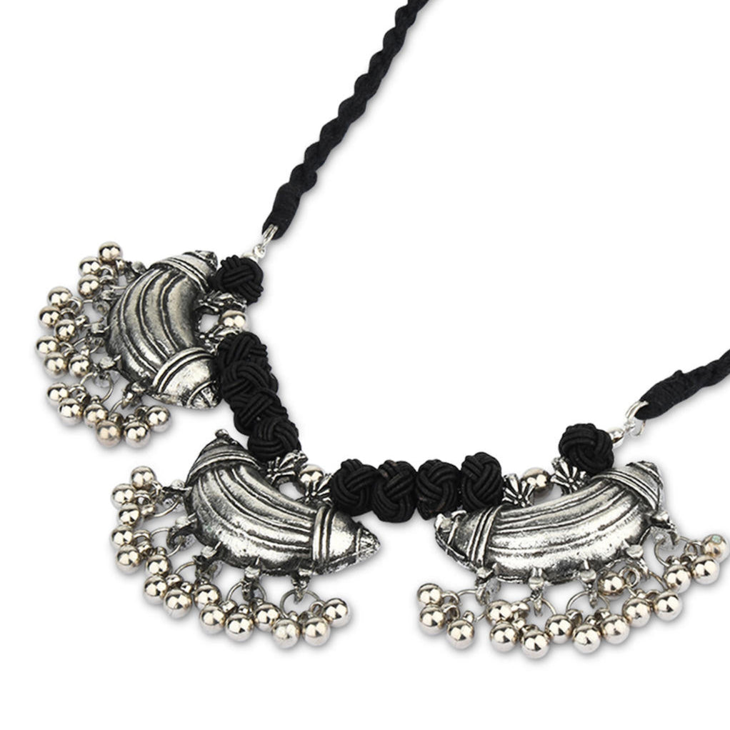 a choker necklace with oxidized silver detailing and black thread closeup on white background