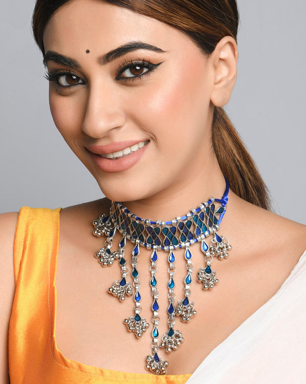 A woman wearing a Peacock Enamel Teardrop Choker Necklace with silver-plated chain and blue enamel pendants.