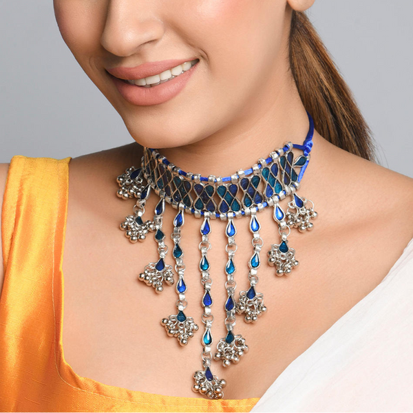 A woman wearing a Peacock Enamel Teardrop Choker Necklace with silver-plated chain and blue enamel pendants.