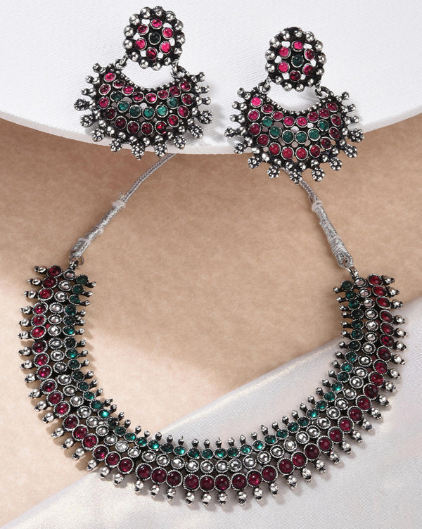 A South Indian traditional silver choker necklace and earrings set with marron and kundan embellishments.